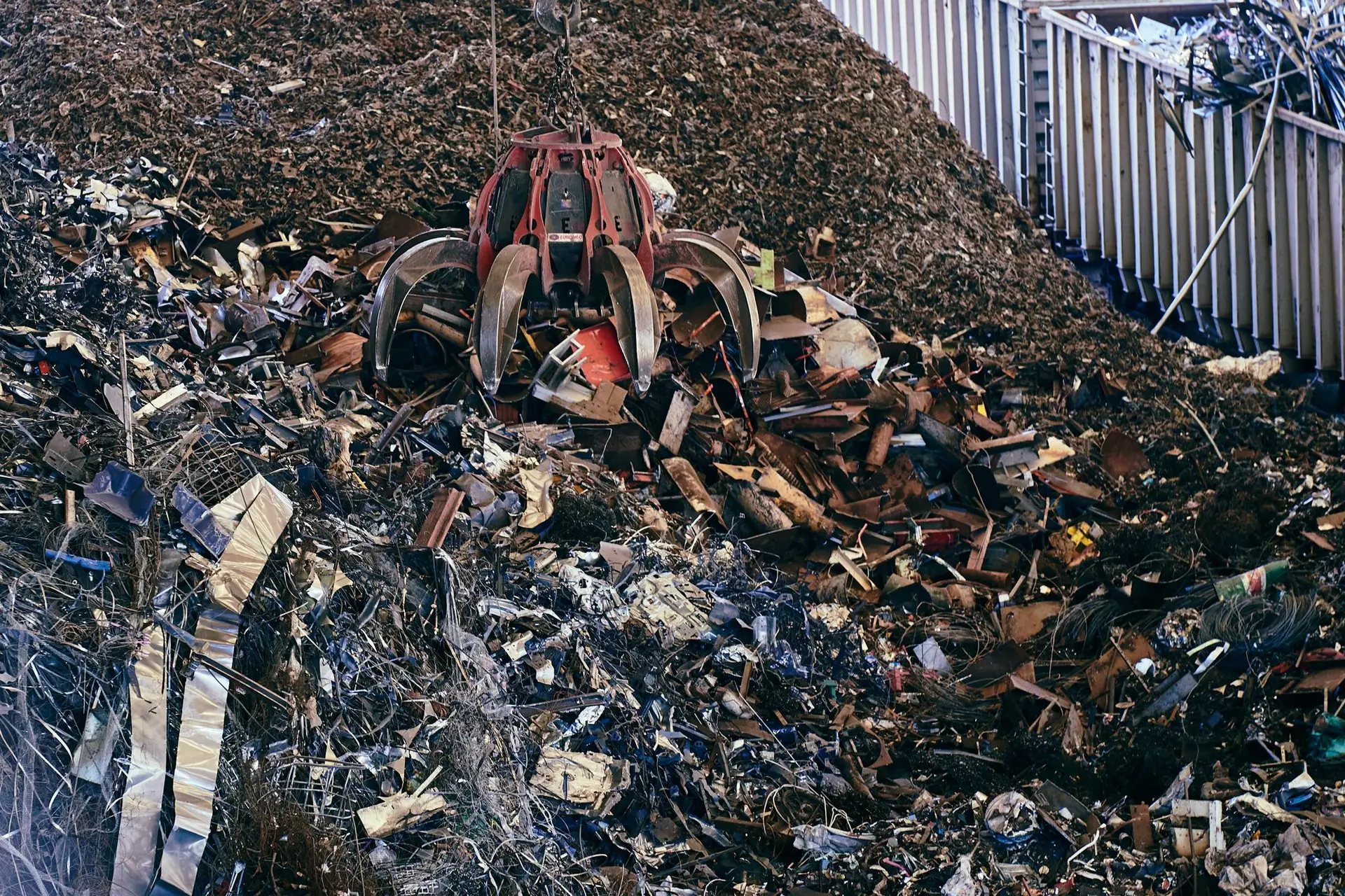 Grab crane lifting heavy melting steel scrap at a recycling yard
